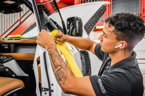 Certified installer applying XPEL Ultimate Plus PPF to a luxury truck at The Specialists in Tucson